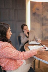 Two women at work on a cell phone calling a depression counselor near me